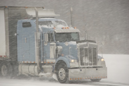Semi truck driving in snowstorm