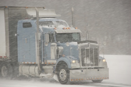 Semi truck driving in snowstorm 