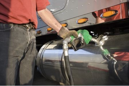 Truck driver filling truck with diesel fuel