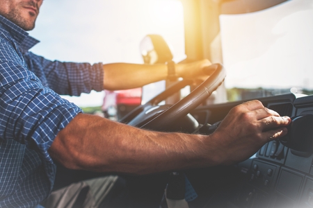 Truck Driver with hands on steering wheel driving safely