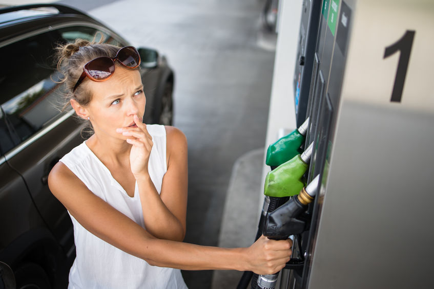 Young Woman Pumping Gas at Gas Station