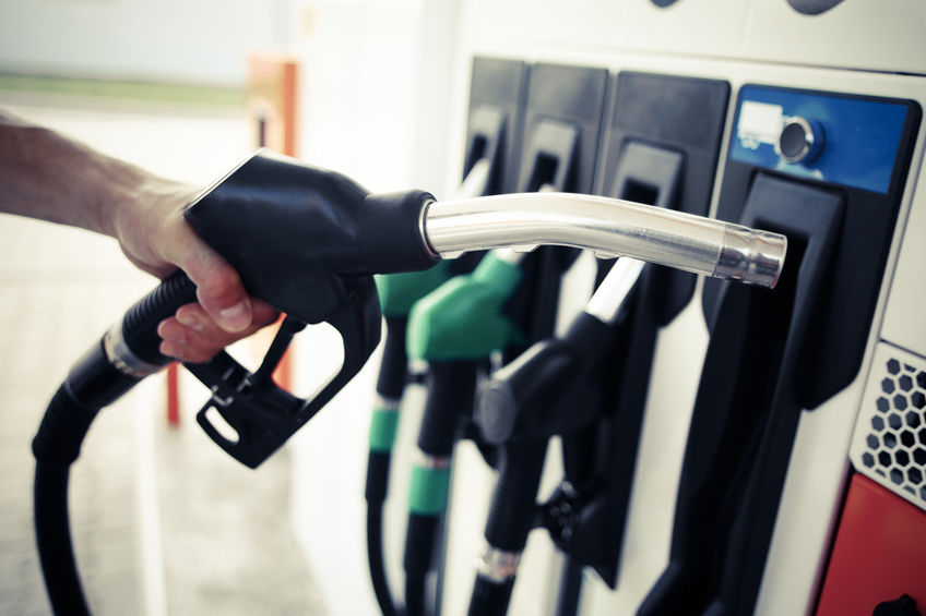 Truck driver's hand holding a fuel pump at a station