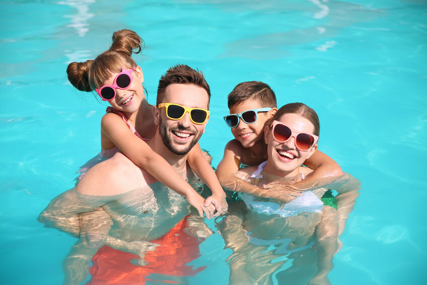 Truck driver on vacation in pool with his wife and two children