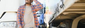 Professional truck driver standing in front of the semi truck